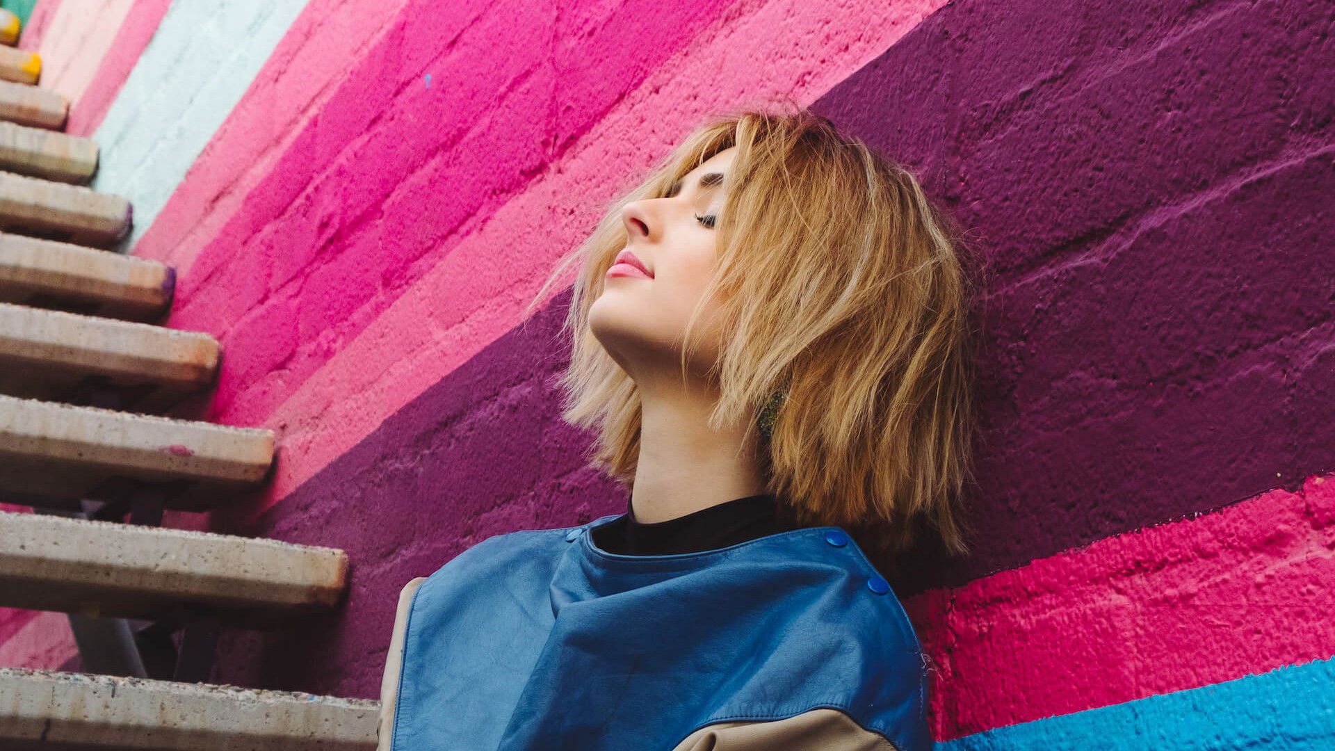 a woman sitting with her back facing a wall