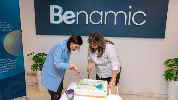 Benamic employees cutting celebratory cake for new hybrid office space.