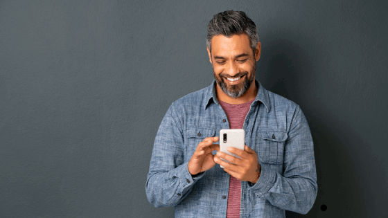 Man smiling looking at his smartphone